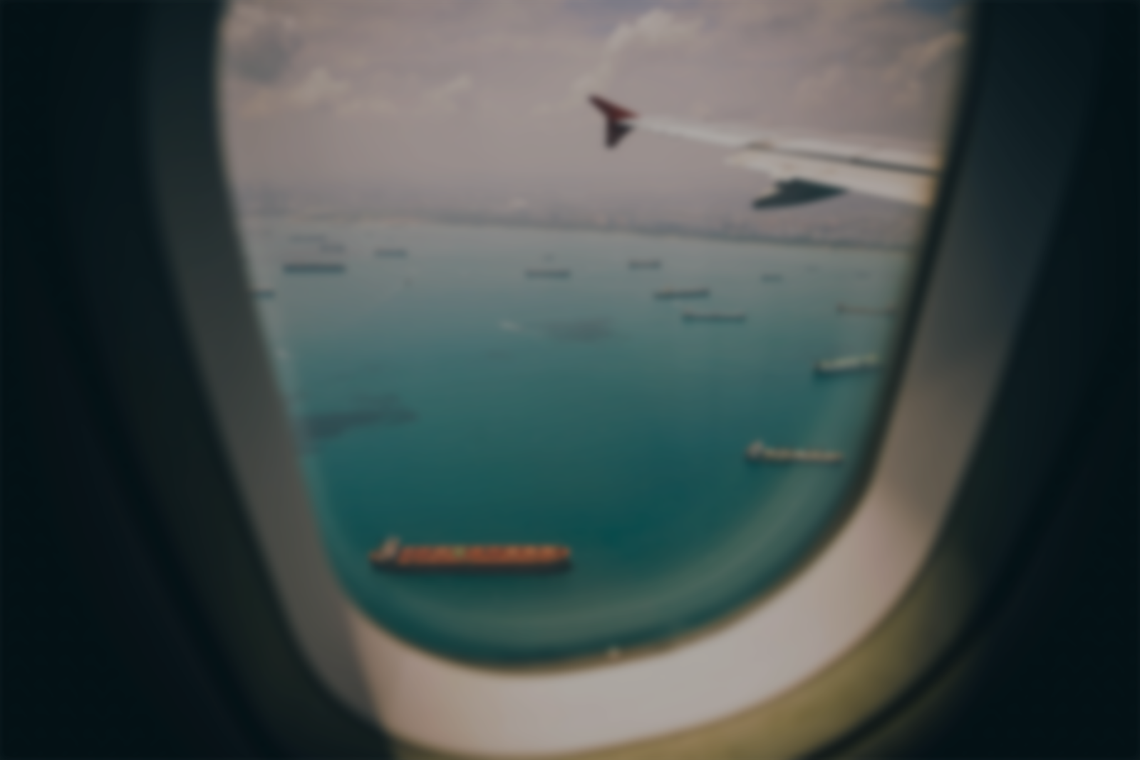 Paysage de bateaux cargos transportants des marchandises à travers un hublot d'avion